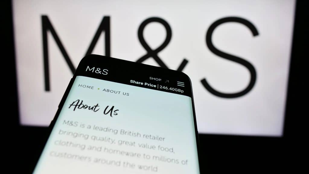 The bbc, the royal family and m&s: a year of crisis for british institutions 3 Marks & spencer logo with a phone in front of it showing the company's website